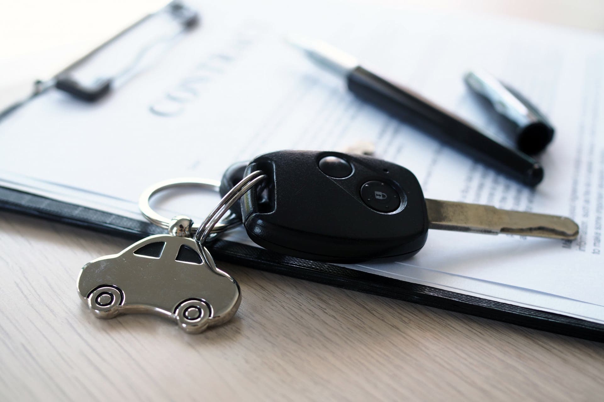 Car keys and keyring resting on a signed loan agreement