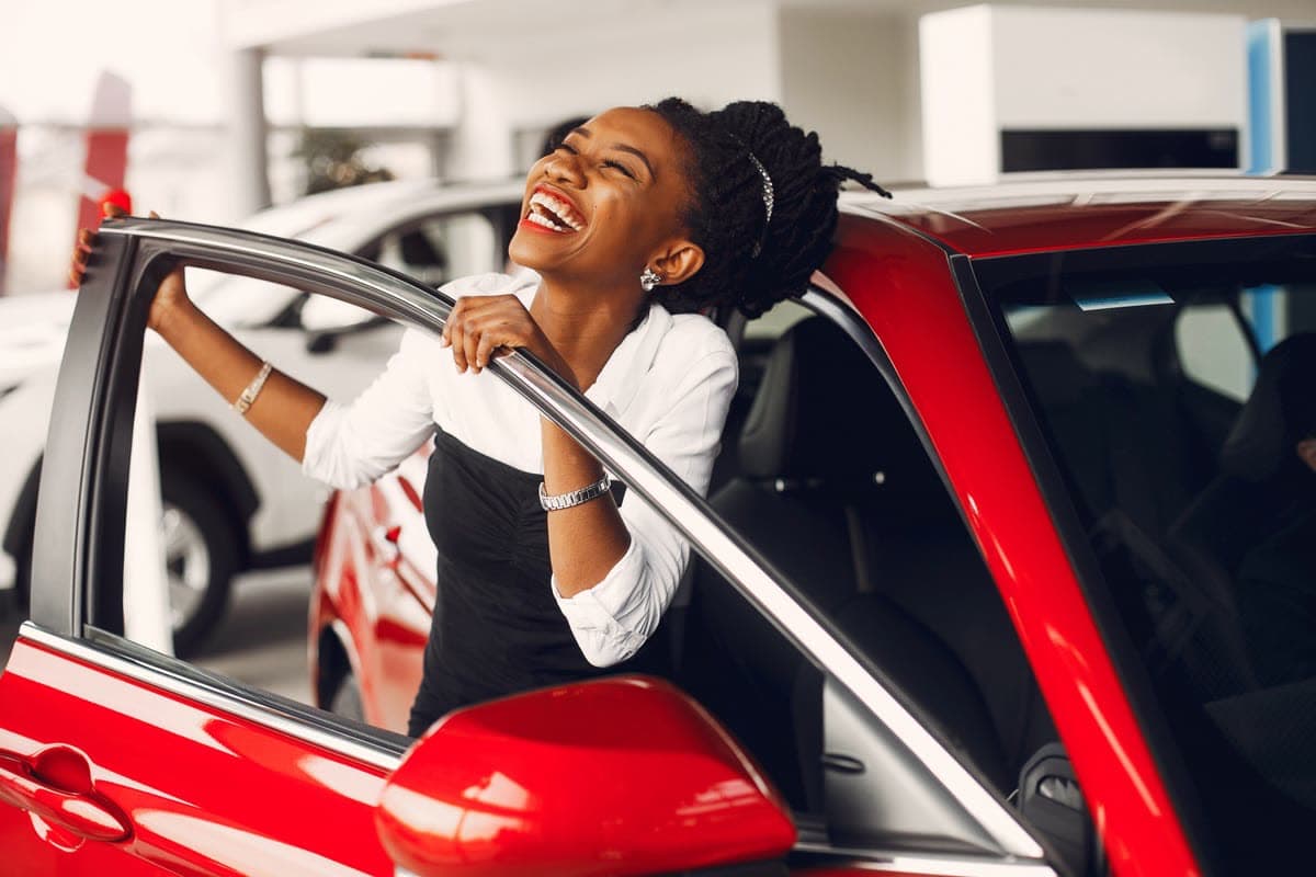 A customer smiling as she gets into her car after a Wilshare Pawnshop vehicle assessment